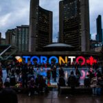 Vibrant evening at Toronto City Hall with festive crowd enjoying the cityscape.