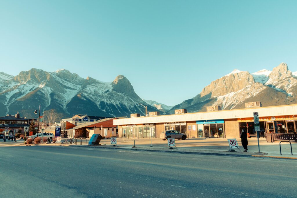 Picturesque view of a mountain town during the day surrounded by stunning snow-capped peaks.