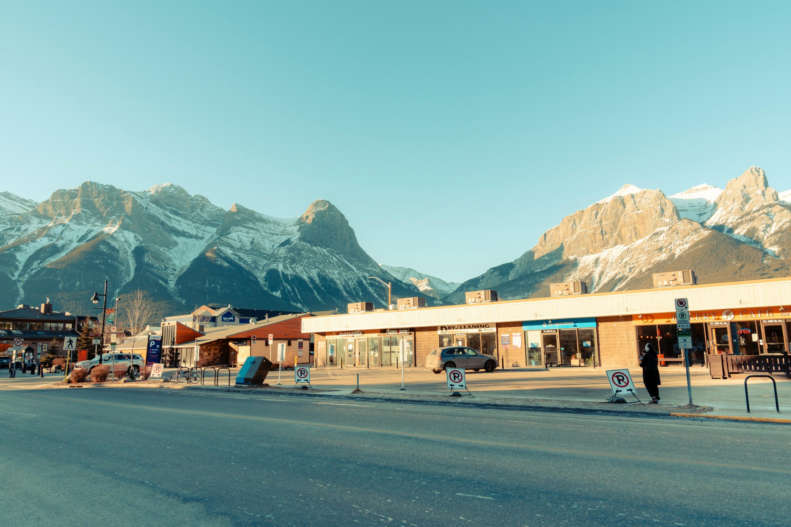 Picturesque view of a mountain town during the day surrounded by stunning snow-capped peaks.