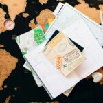 A flat lay of travel planning items on a map, featuring a compass, notebook, and guide for wanderlust enthusiasts.